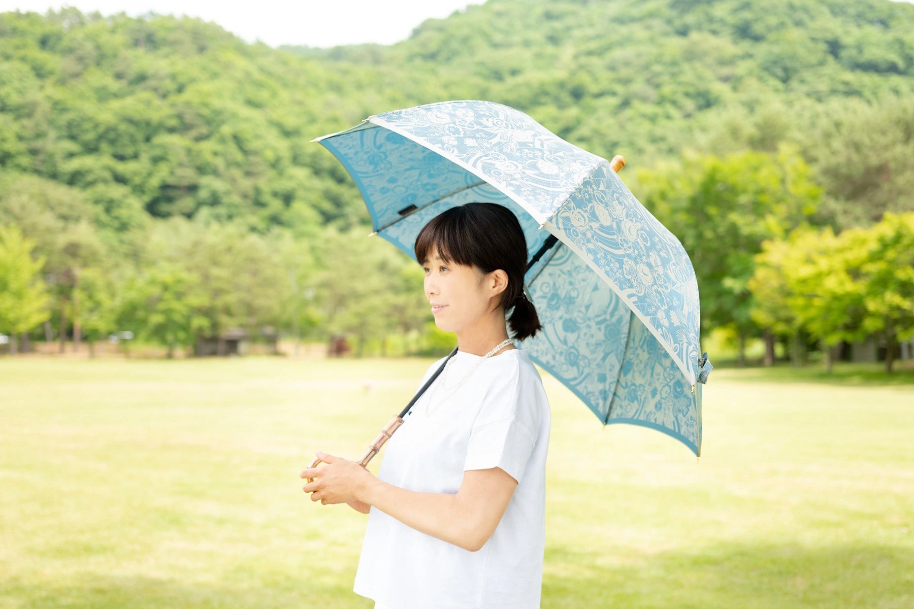 水色の晴雨兼用傘婦人長傘を差す様子